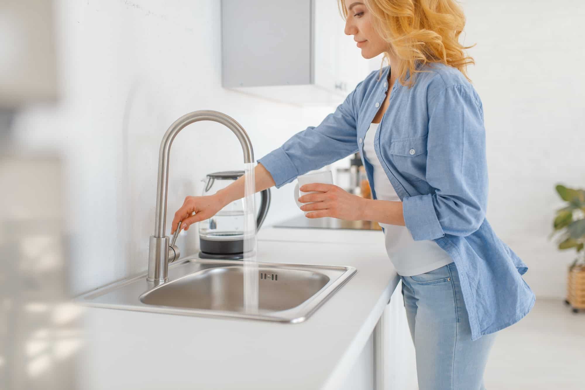 Washing water. Женщина на кухне у раковины. Женщина в раковине. Человек у раковины. Девушка с умывальником.